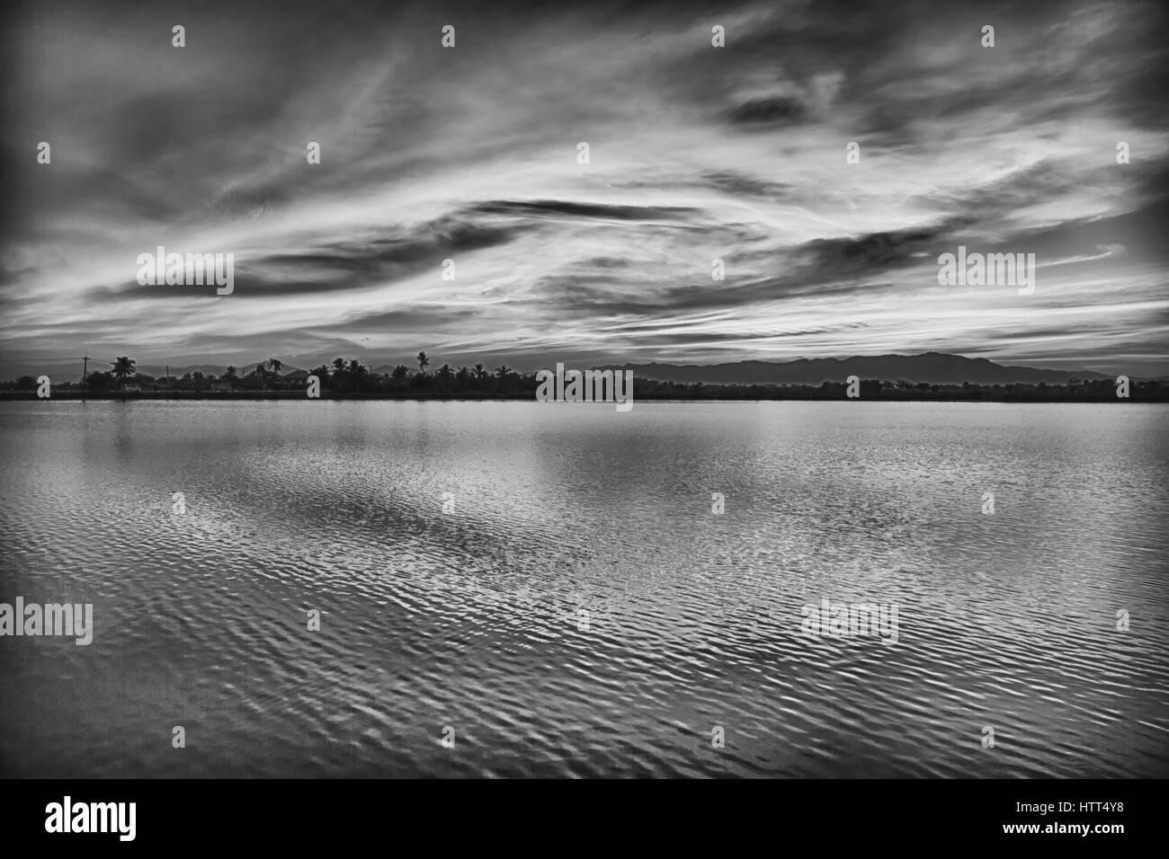 Blick vom Wasser auf den Sonnenaufgang voller Farben und Regen Konzept der Entspannung Stockfoto