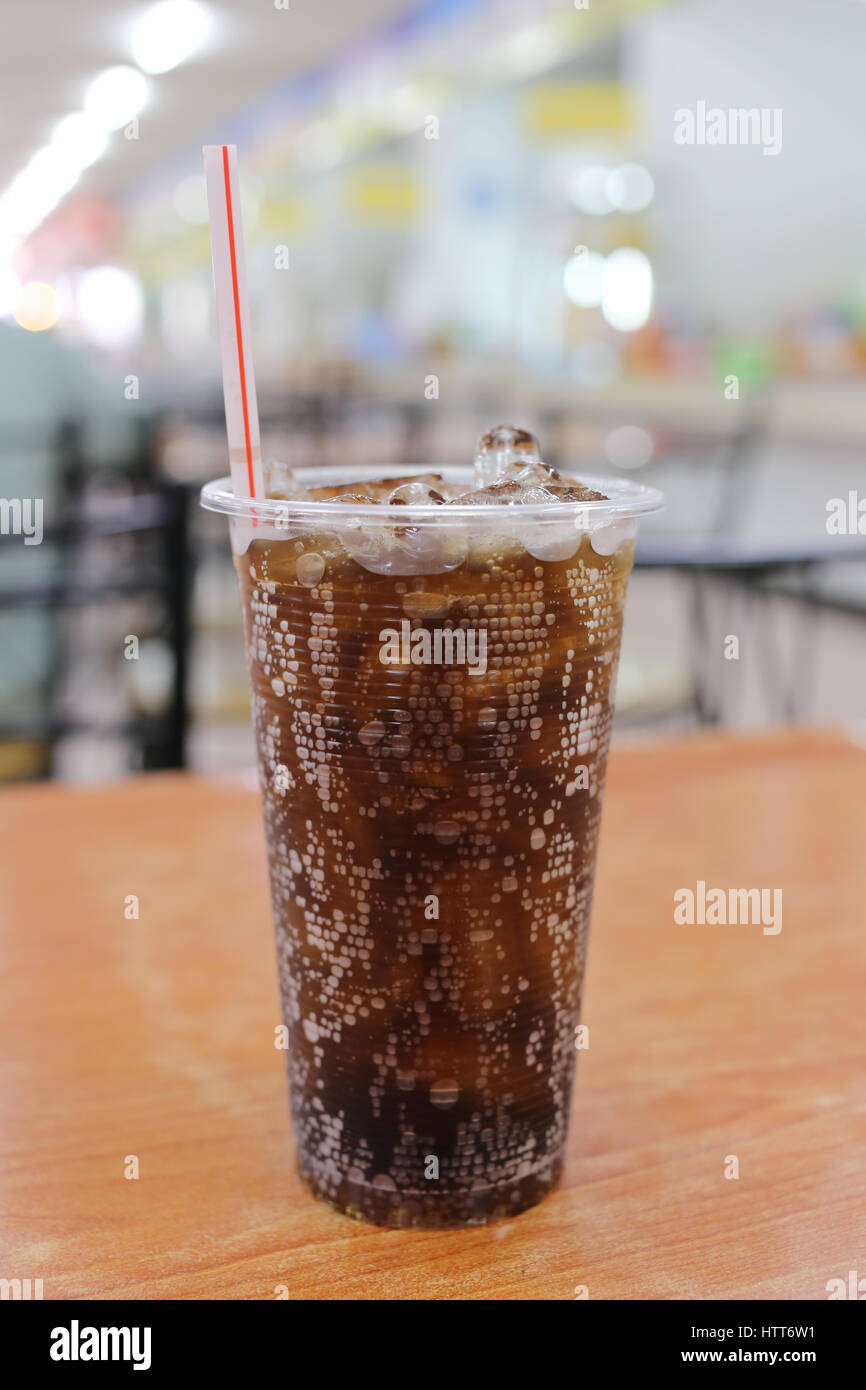 Kalte Cola in einem Glas auf einem hölzernen Tisch in einem Restaurant. Stockfoto