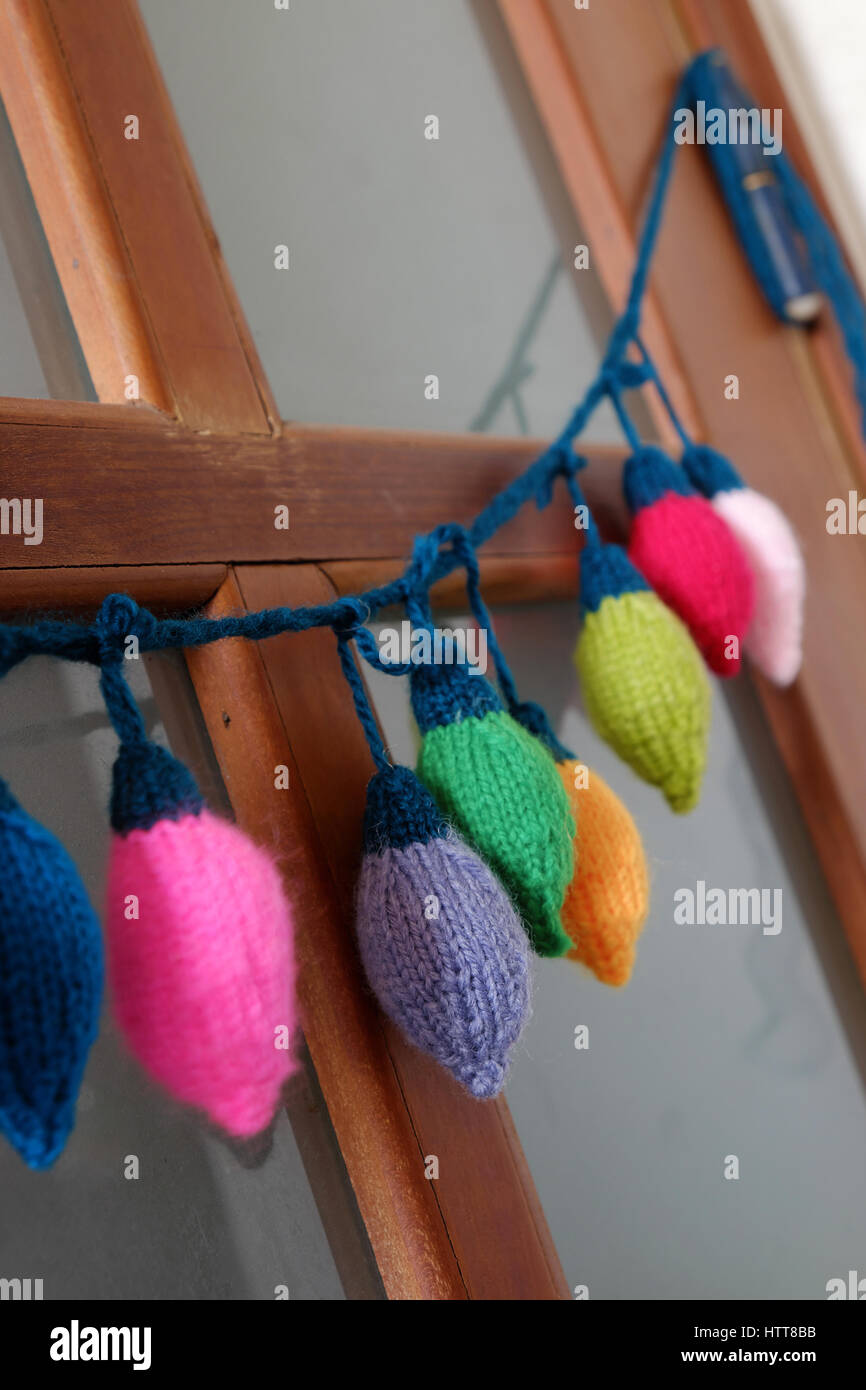 Gruppe von bunten Xmas Ornament für Winterurlaub, handgefertigtes Produkt, gestrickte Weihnachten Lichter Lampe hängen an der Tür Stockfoto