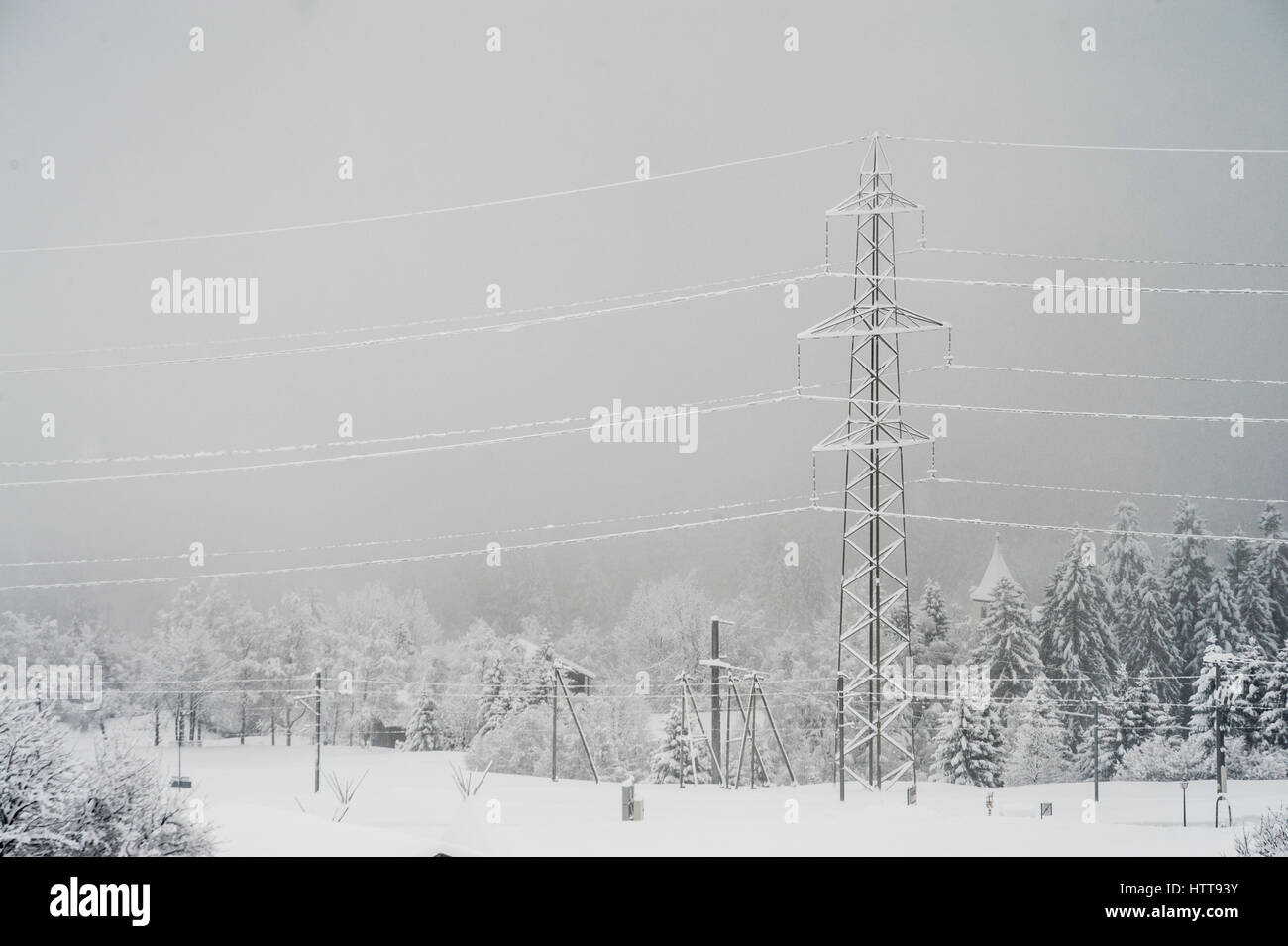 Gefrostet Strommasten und Bäume an einem nebligen kalten Wintertag bei Disentis, Schweiz Stockfoto