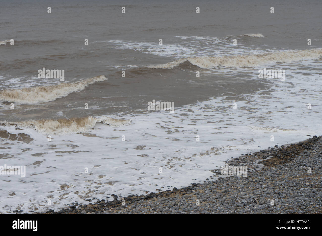 Sanfte Wellen brechen sich an einer Springflut in Cromer, Norfolk. Stockfoto