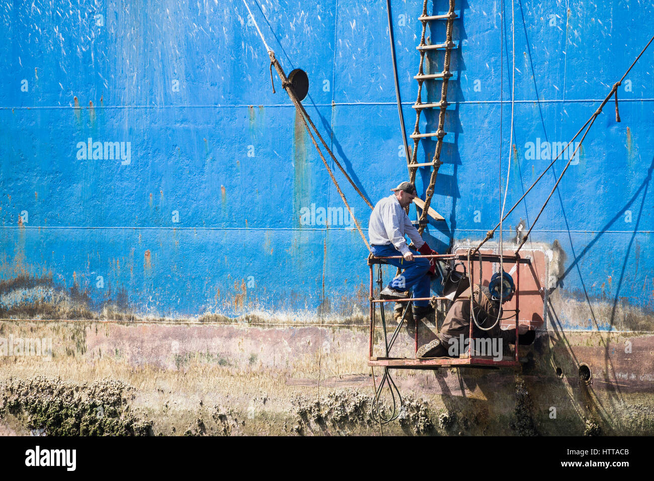 Schweißer arbeiten von behelfsmäßigen Plattform Reparatur Rost russische Trawler Im Las Palmas Hafen auf Gran Canaria. Stockfoto