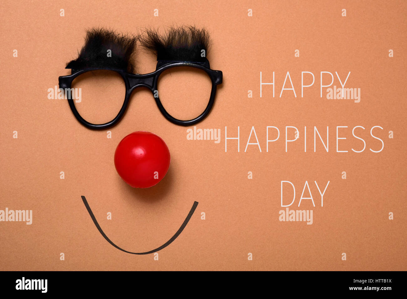 der Text glücklich Glück Tag und ein paar Brillen mit buschigen Augenbrauen, eine rote Clownsnase und ein Lächeln auf braunem Hintergrund gezeichnet Stockfoto