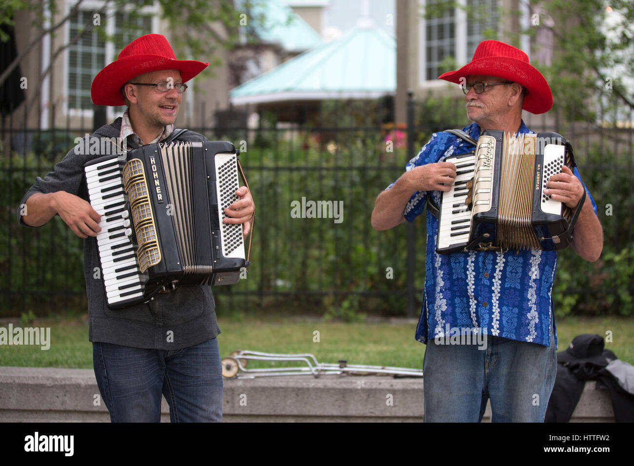 Buskerjames, Gaukler, Akkordeon zu spielen, während Kanada Day Feierlichkeiten in Eau Claire, Innenstadt von Calgary Stockfoto