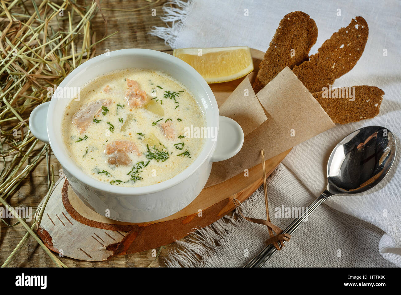 Rahmsuppe mit Kartoffeln, Lauch und Erbsen auf Holztisch. Curry Karottensuppe mit Sahne und frischen Kräutern Stockfoto