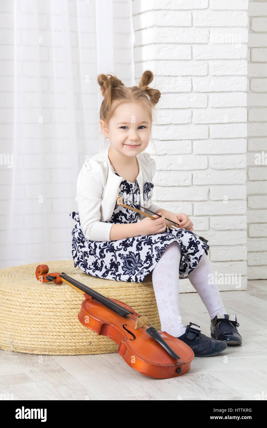 kleines Mädchen sitzt, hält eine Bogen und Lächeln Sprache Stockfoto