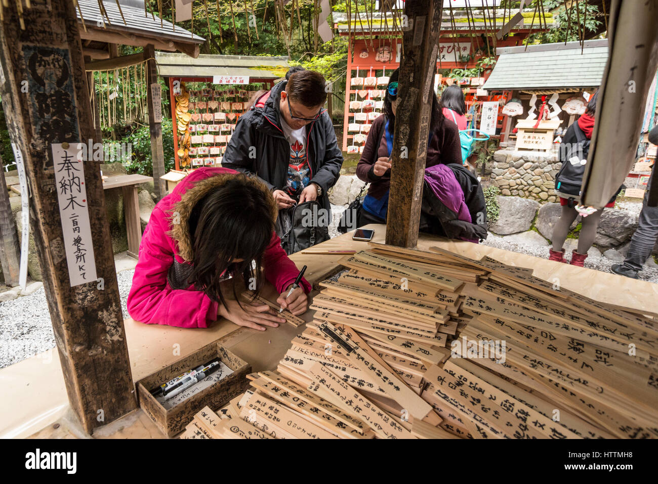 Eine Frau schreiben Gebet auf einer hölzernen Tafel oder Ema Nonomiya Shinto Schrein, Arashiyama Bezirk in Kyoto, Japan Stockfoto