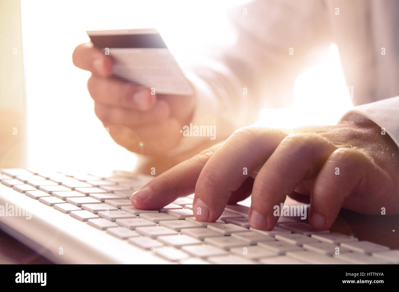 Nahaufnahme des Mannes Hände halten Kreditkarte und Computer-Tastatur. Konzept für e-Commerce, Online-shopping, e-Banking, Internet-Sicherheit. Stockfoto