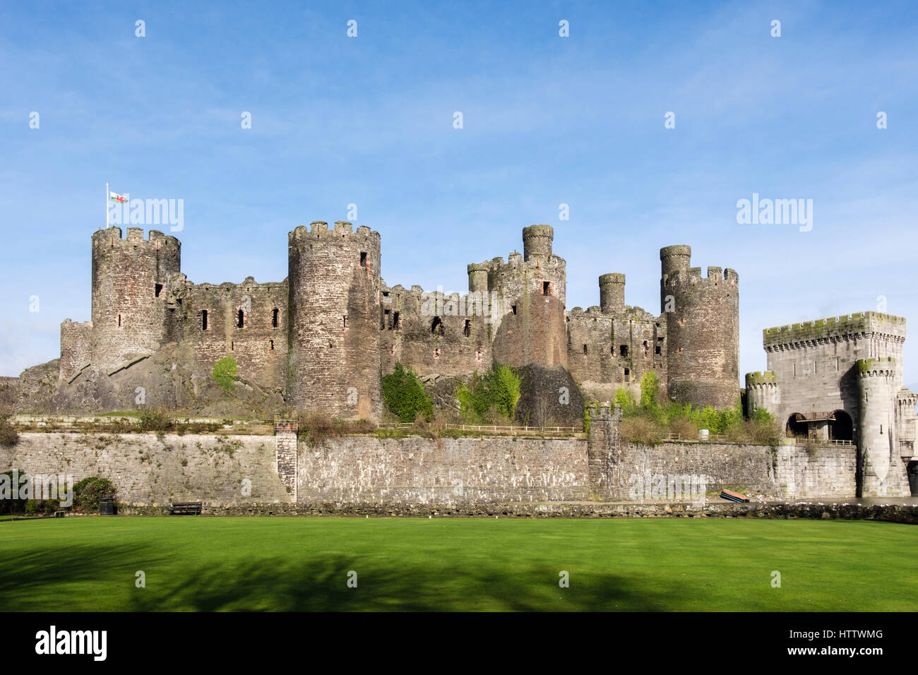 Conwy Castle Zinnen auf Türme und Mauern mit walisische Flagge von außen gesehen. Conwy, Wales, UK, Großbritannien, Europa Stockfoto