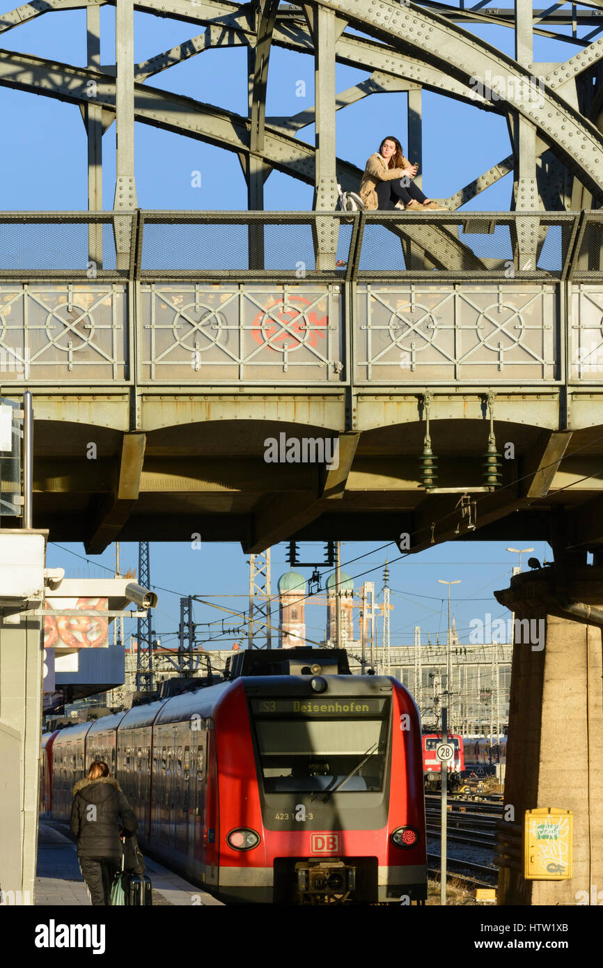 München, München, Frau sitzt im Rahmen der Straßenbrücke Hackerbrücke, S-Bahn-Zug, Kirche, Frauenkirche, Oberbayern, Oberbayern, Bayern, Bav Stockfoto