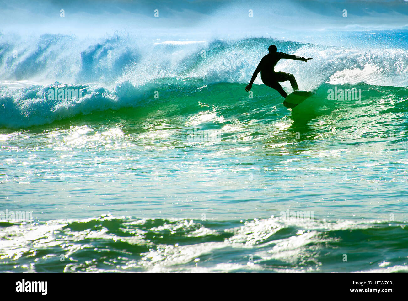Silhouette eines Surfers auf einer Welle im Ozean Stockfoto