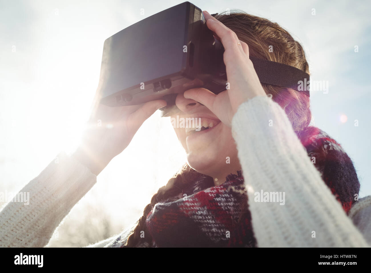 Frau in Winterkleidung mit VR Kopfhörer Stockfoto