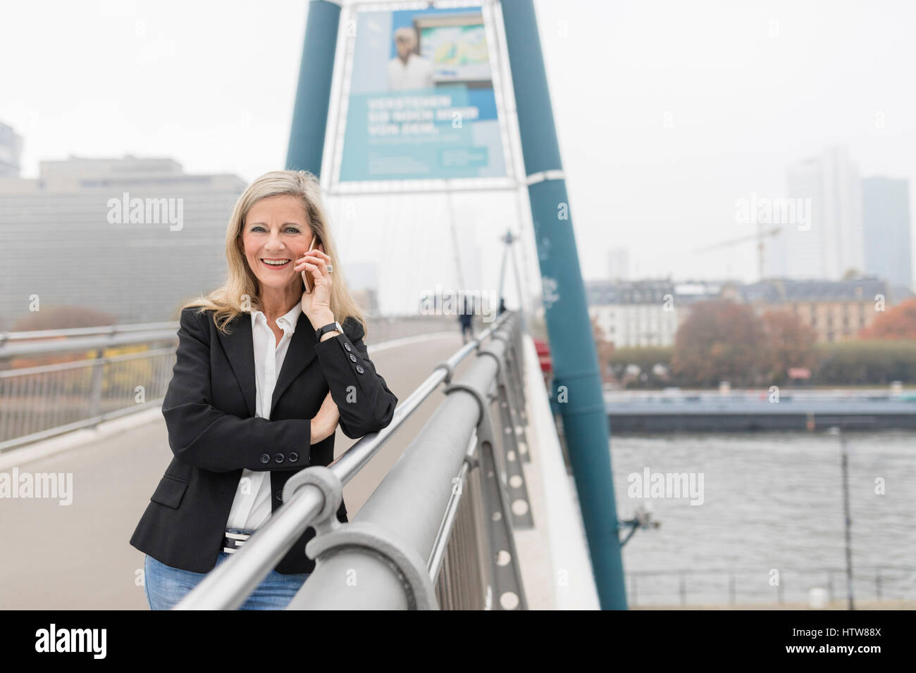 Geschäftsfrau, die auf einer Brücke telefonieren Stockfoto