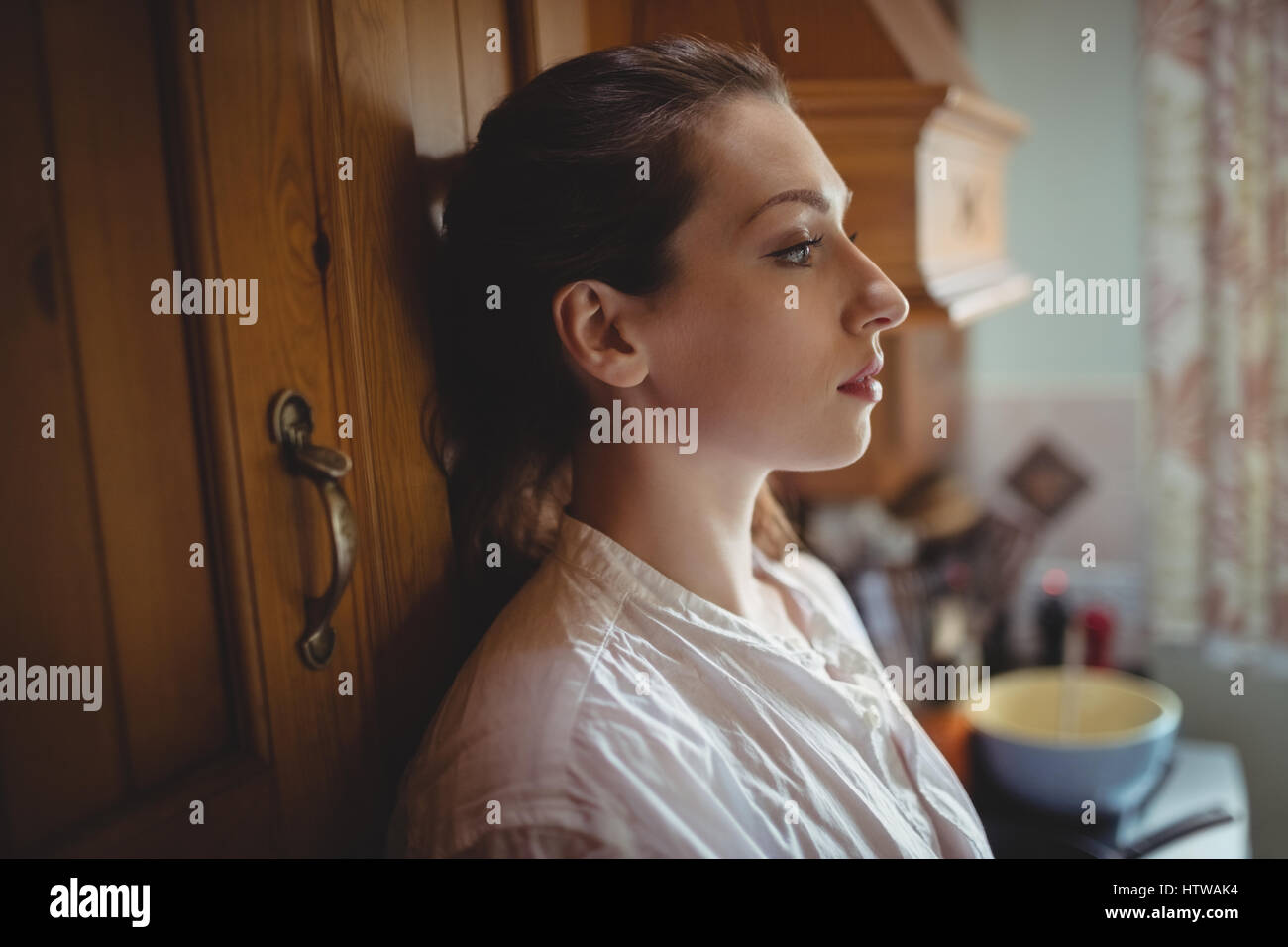 Nachdenkliche Frau sitzt in Küche Stockfoto