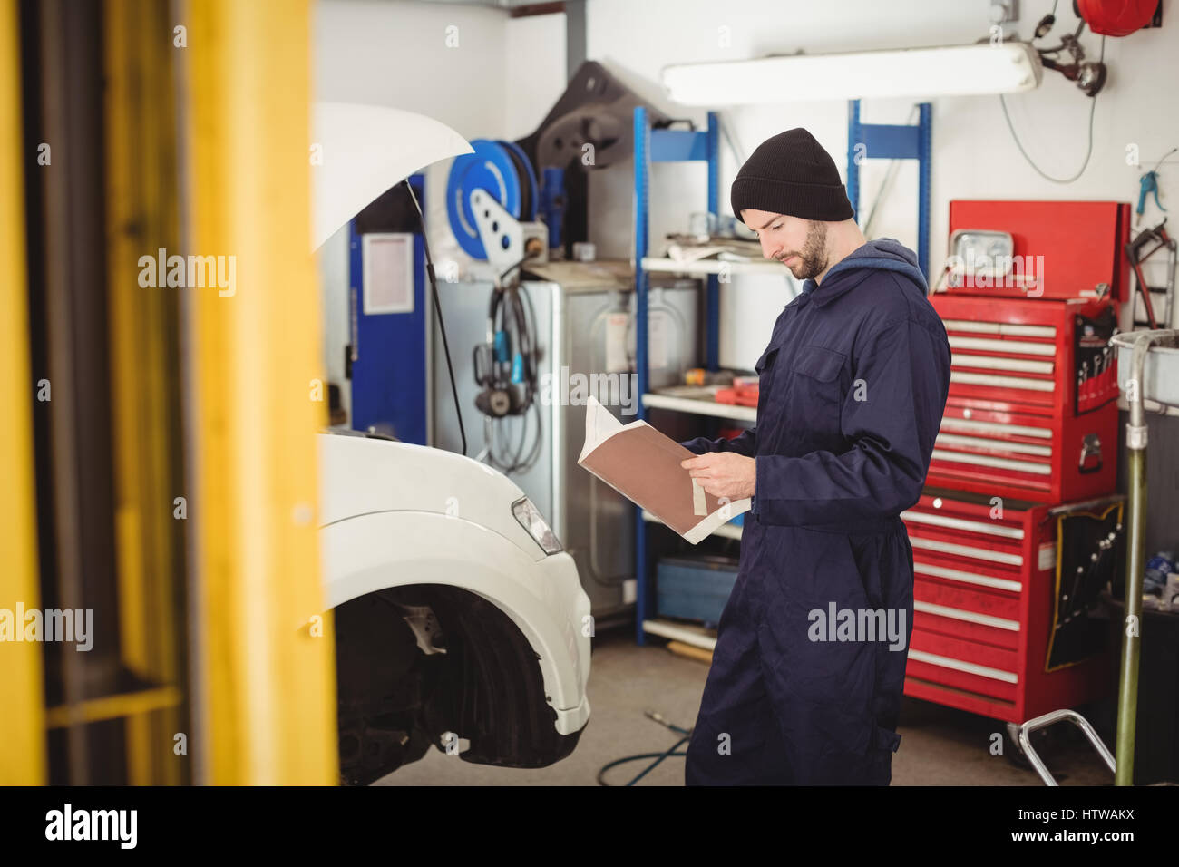 Mechaniker, die manuelle Lehrbuch lesen Stockfoto