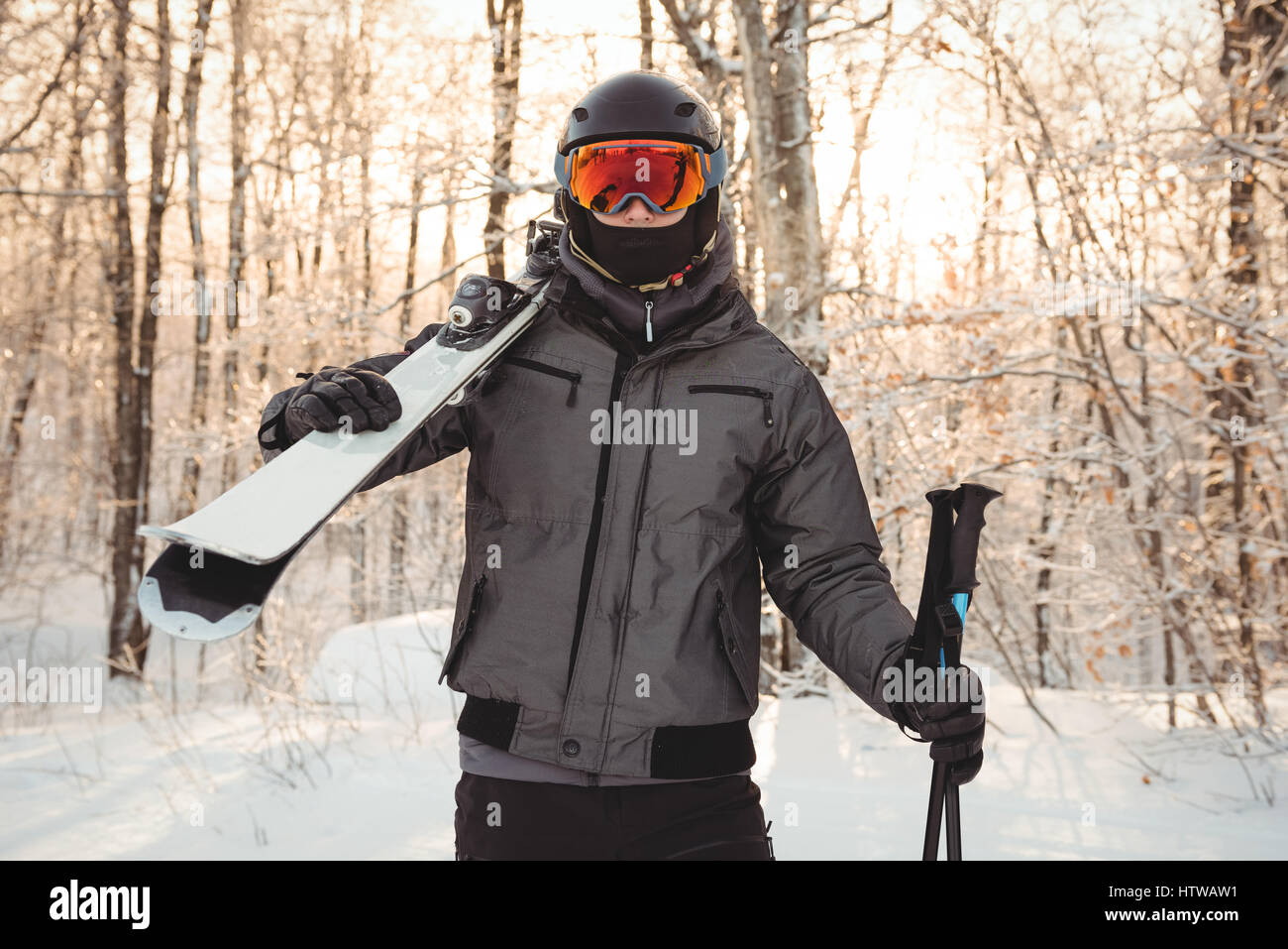 Mann in Skibekleidung Ski auf ihrer Schulter hält Stockfoto