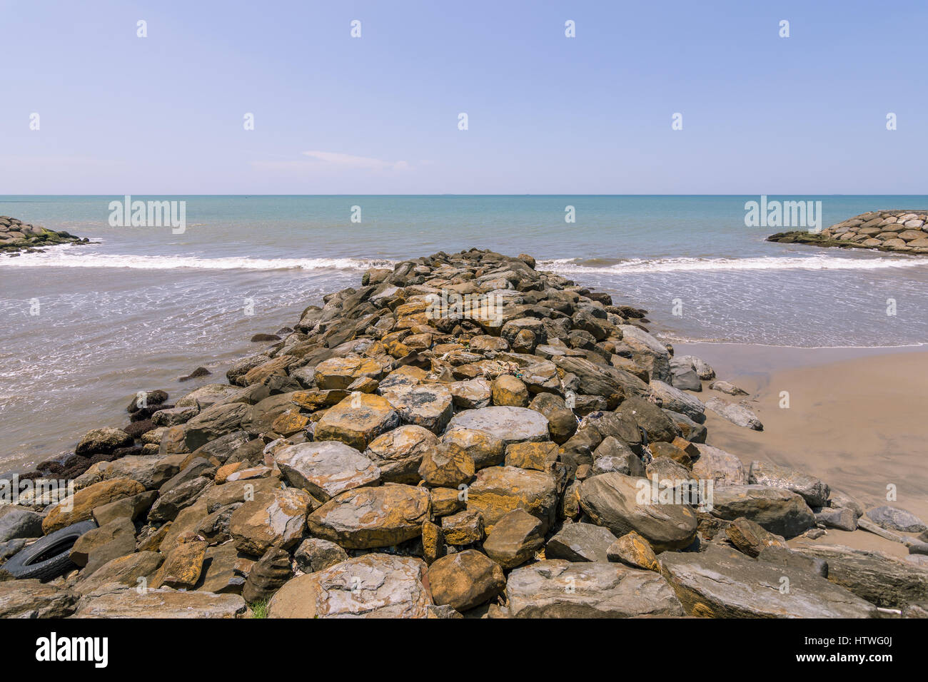 Künstlicher Felsen Buhne zu einem ruhigen asiatischen Meer ragt. Stockfoto