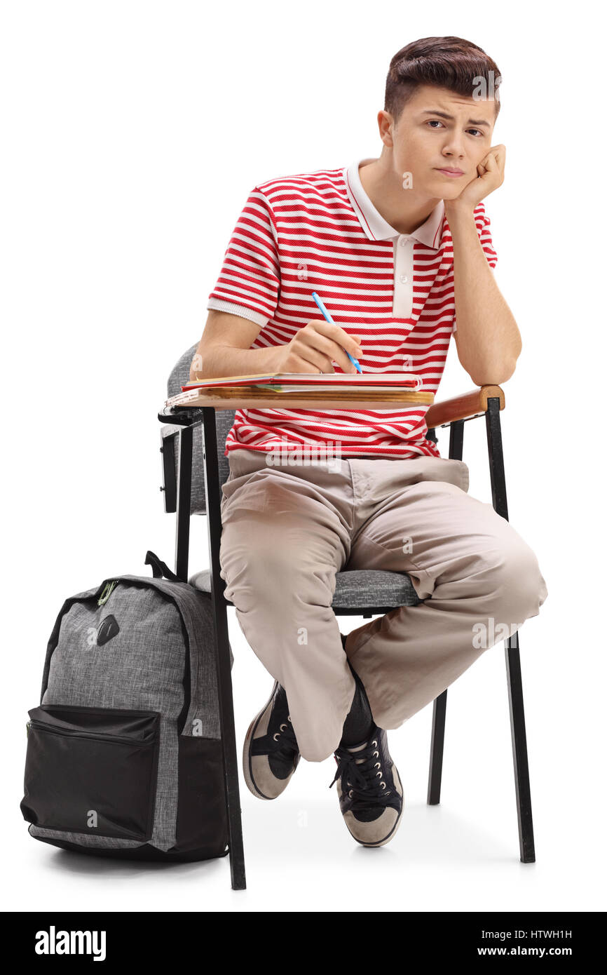 Gelangweilte Teenager-Studentin in einem Sessel sitzend und mit Blick auf die Kamera isoliert auf weißem Hintergrund Stockfoto