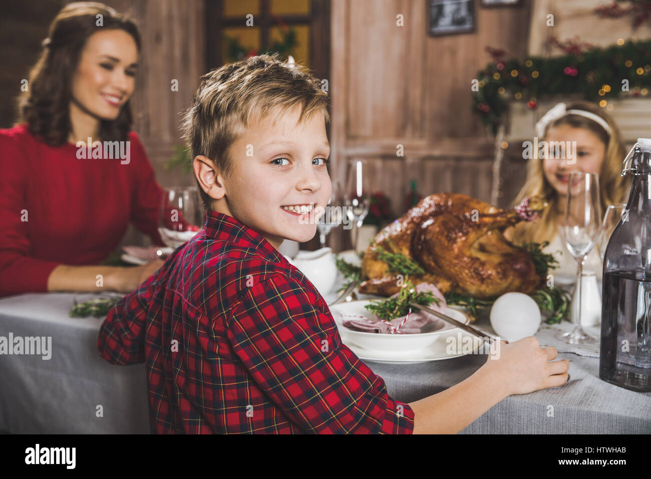Glückliche Familie sitzt am Tisch Urlaub zur Weihnachtszeit Stockfoto