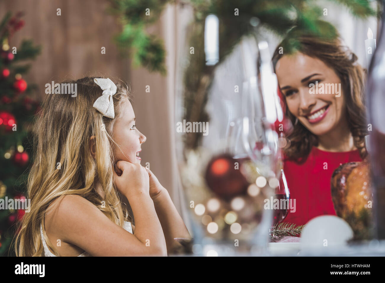 Glückliche Mutter und Tochter sitzen am Tisch Urlaub zur Weihnachtszeit Stockfoto