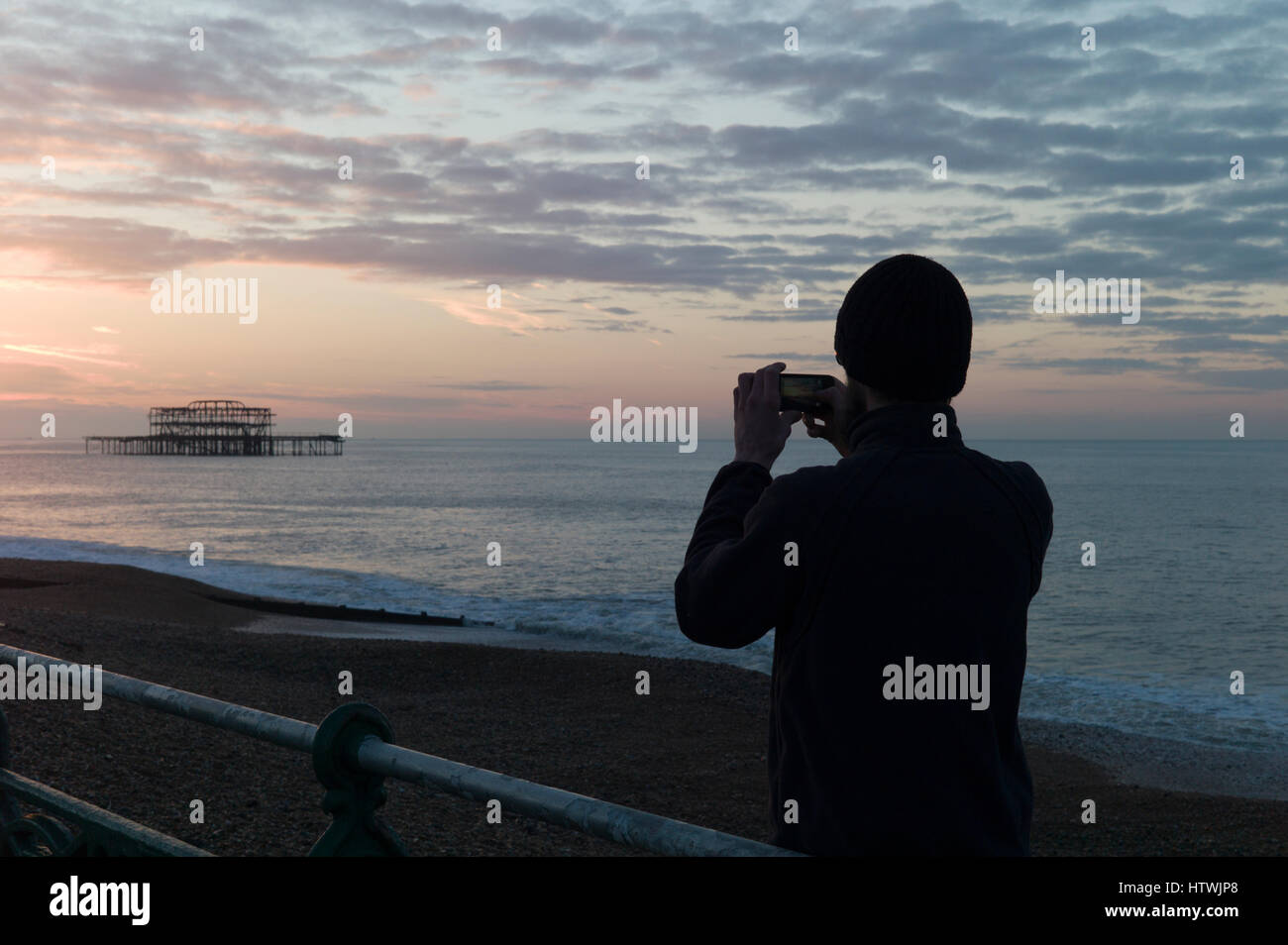 Mann fotografiert von Brighton Pier West auf einem smartphone Stockfoto