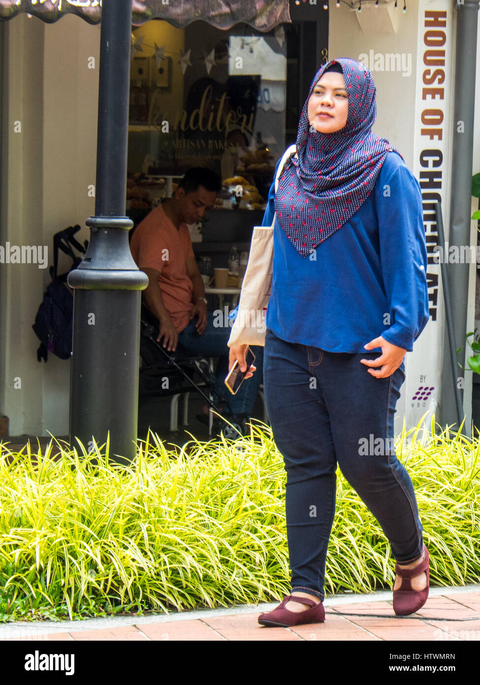 Eine Singapurische Muslimin in Bussorah Pedestrian Mall zu Fuß. Stockfoto