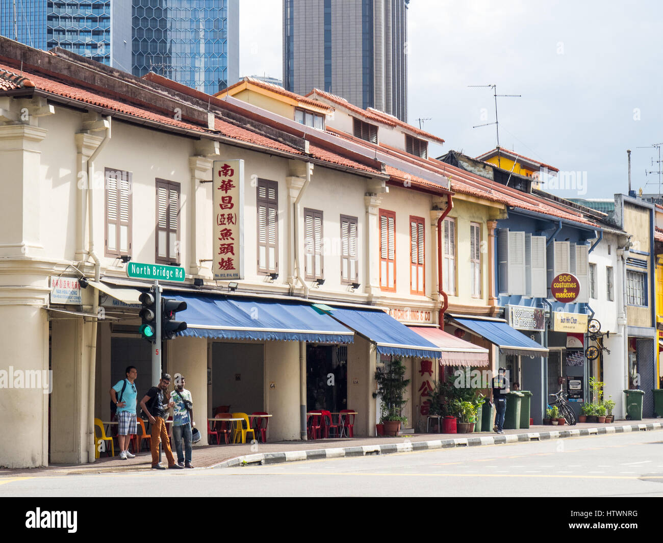 Fußgänger vor einer Reihe von Geschäftshäusern am North Beach Road Singapur. Stockfoto