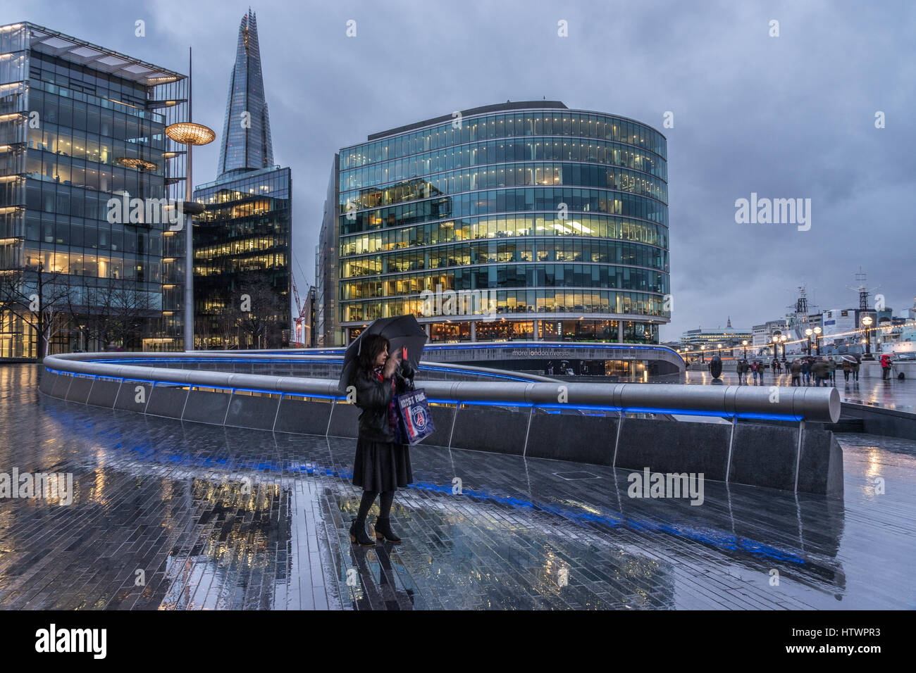 Frau, die eine Selfie draußen im Regen unter Dach in London mit Blick auf die Scherbe in der Stadt. Stockfoto