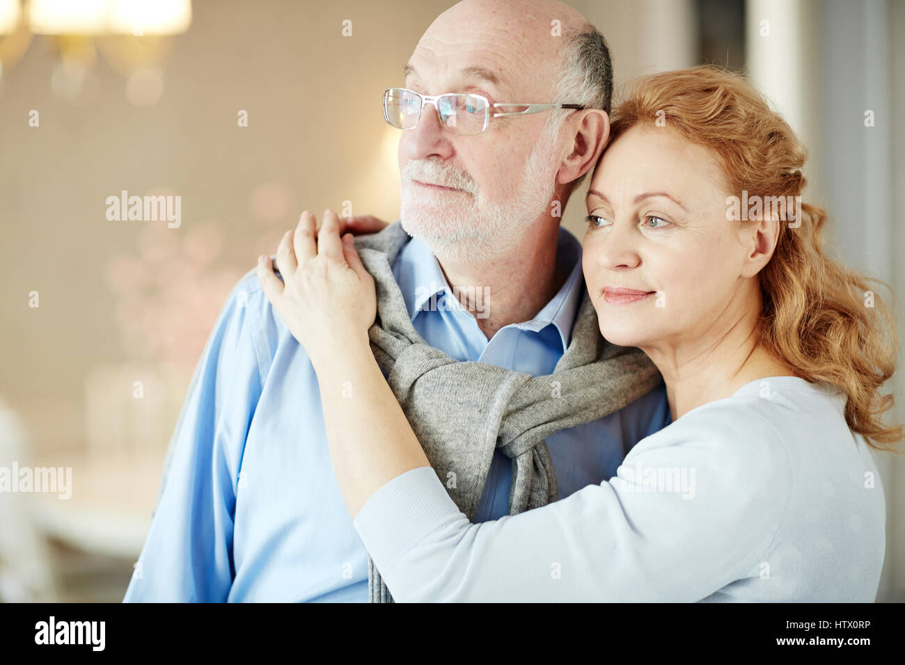 Porträt von älteren Liebespaar umarmt und Lächeln, wegschauen, Fenster genießen ruhigen Lebensabend Tage zu Hause Stockfoto