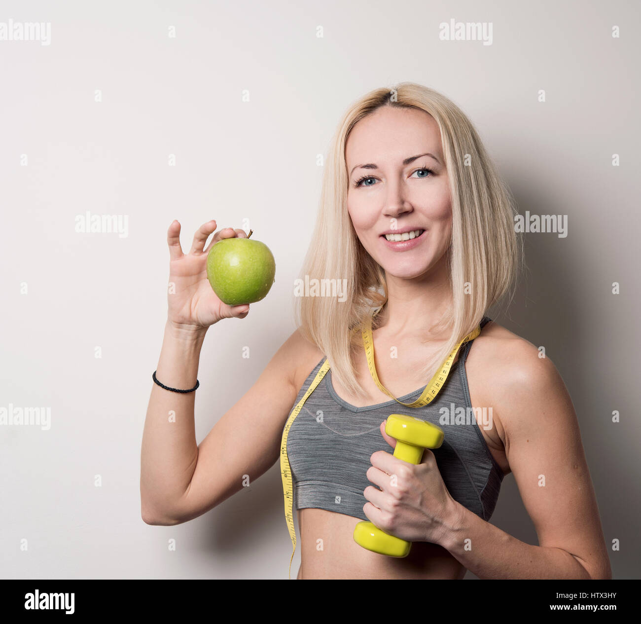 Fitness-Trainer bietet grünen Apfel Stockfoto