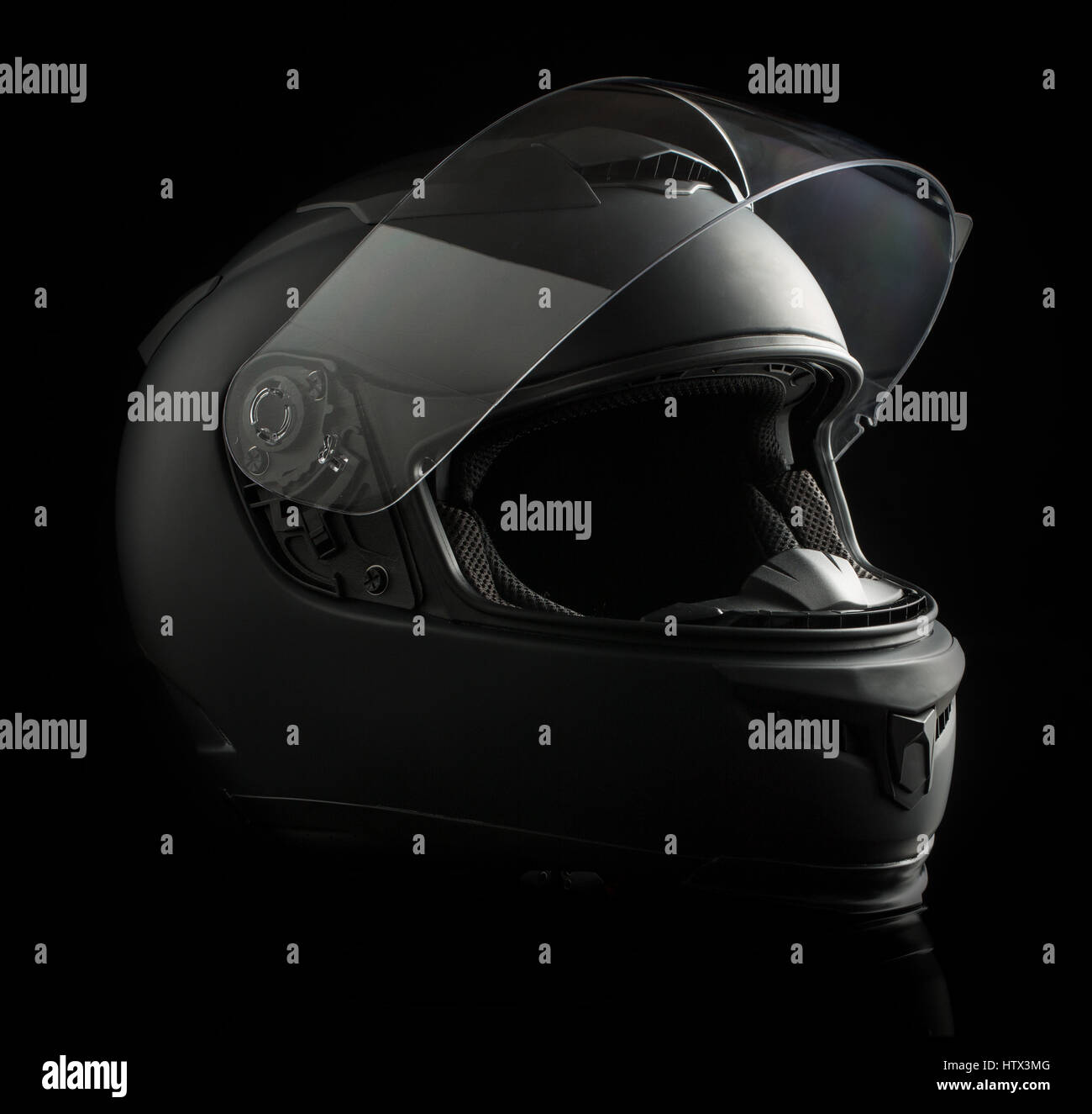 Schwarzer Motorradhelm auf schwarzem Hintergrund. Stockfoto