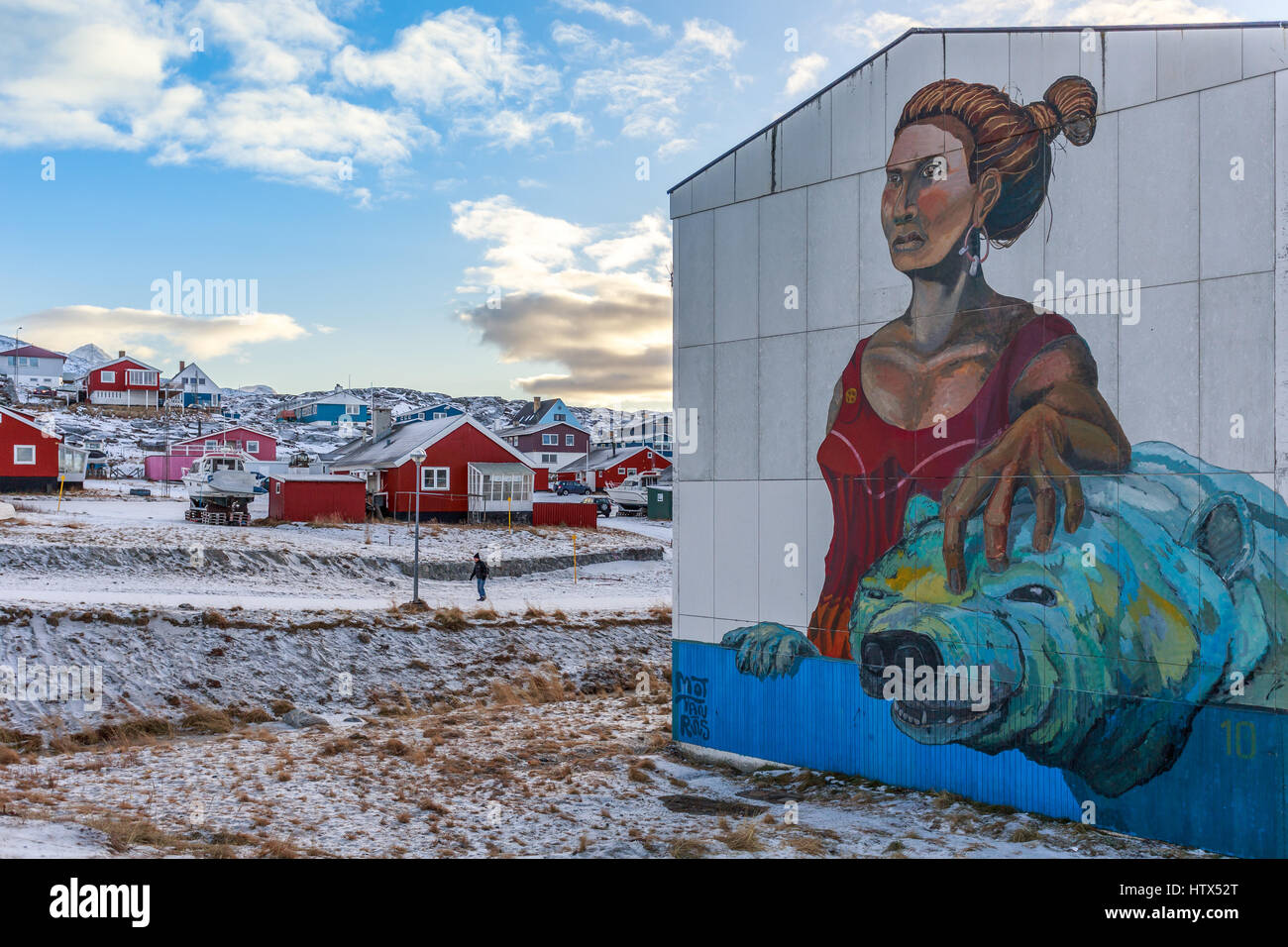 Graffiti mit Frauen und Eisbären an der Wand im Wohnbereich mit Häusern auf dem Hügel im Hintergrund Nuuk, Grönland Stockfoto