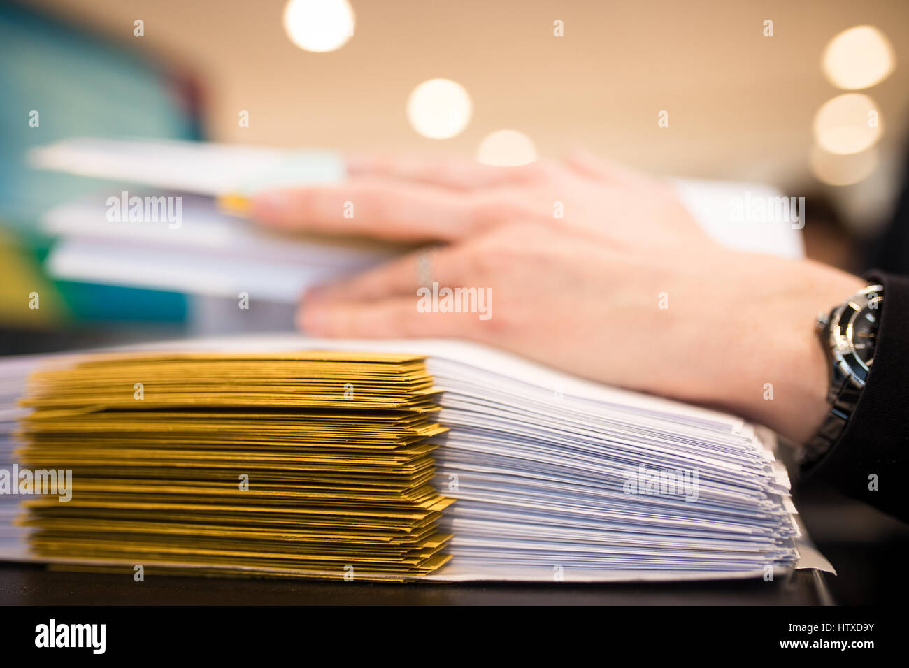Nahaufnahme der weiblichen Hand mit Dossiers im Büro. Arbeiten auf Stapel von Dateien. Flachen DOF Stockfoto