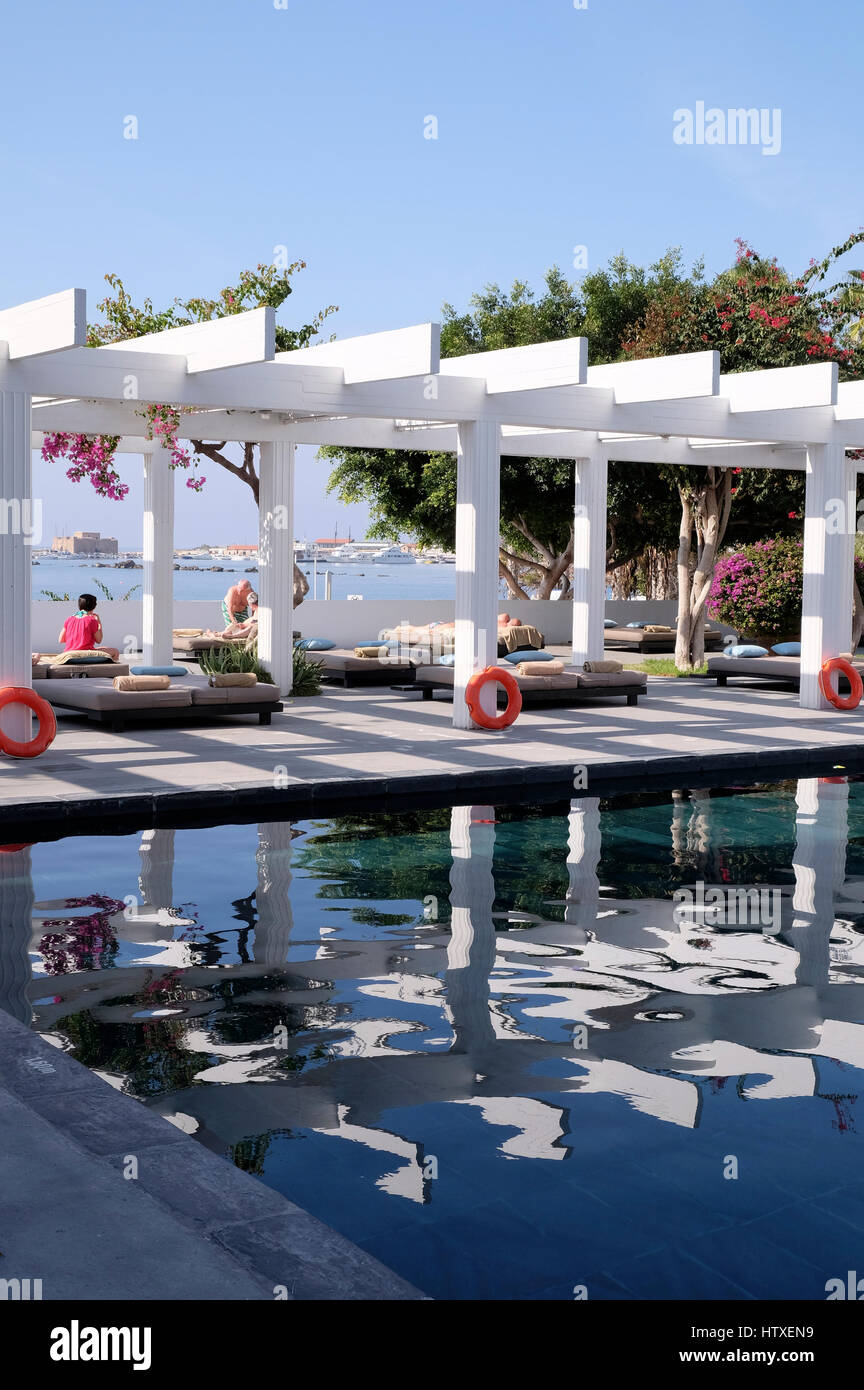 Entspannen am Pool im Almyra Hotel, Paphos, Zypern.  Blick auf die Festung und den Hafen hinaus. Stockfoto