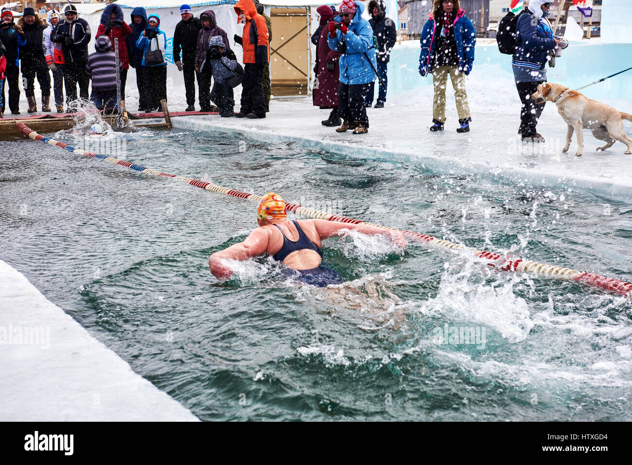 SAHYURTA, Gebiet IRKUTSK, Russland - März 11.2017: Cup des Baikalsees. "Frierbäder". Schmetterling. Frau schwimmt energisch Stockfoto