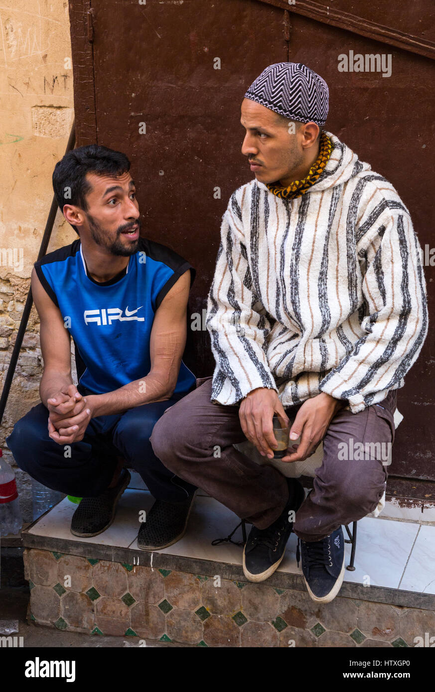 Fes, Marokko.  Zwei junge Männer sprechen in der Altstadt. Stockfoto
