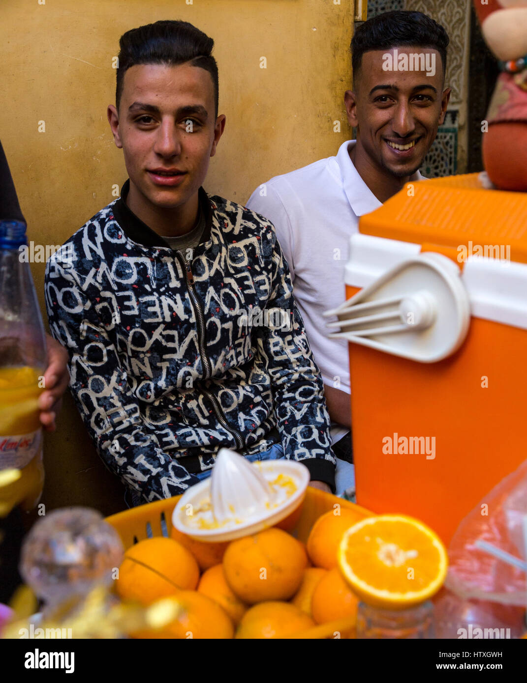 Fes, Marokko.  Zwei junge Männer verkaufen Orangensaft in der Medina. Stockfoto