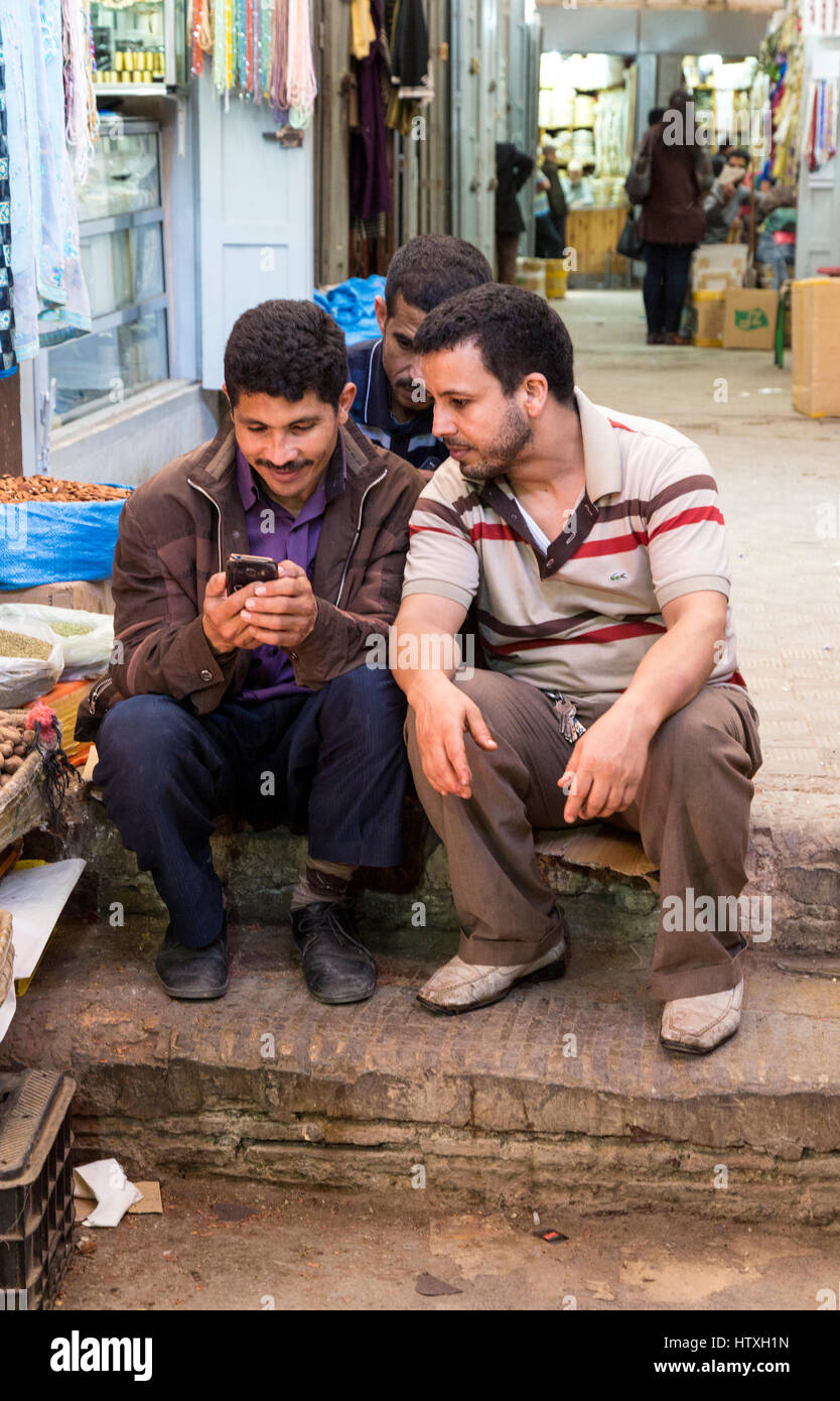 Fes, Marokko.  Junge Männer, die ein Handy in der Medina zu überprüfen. Stockfoto