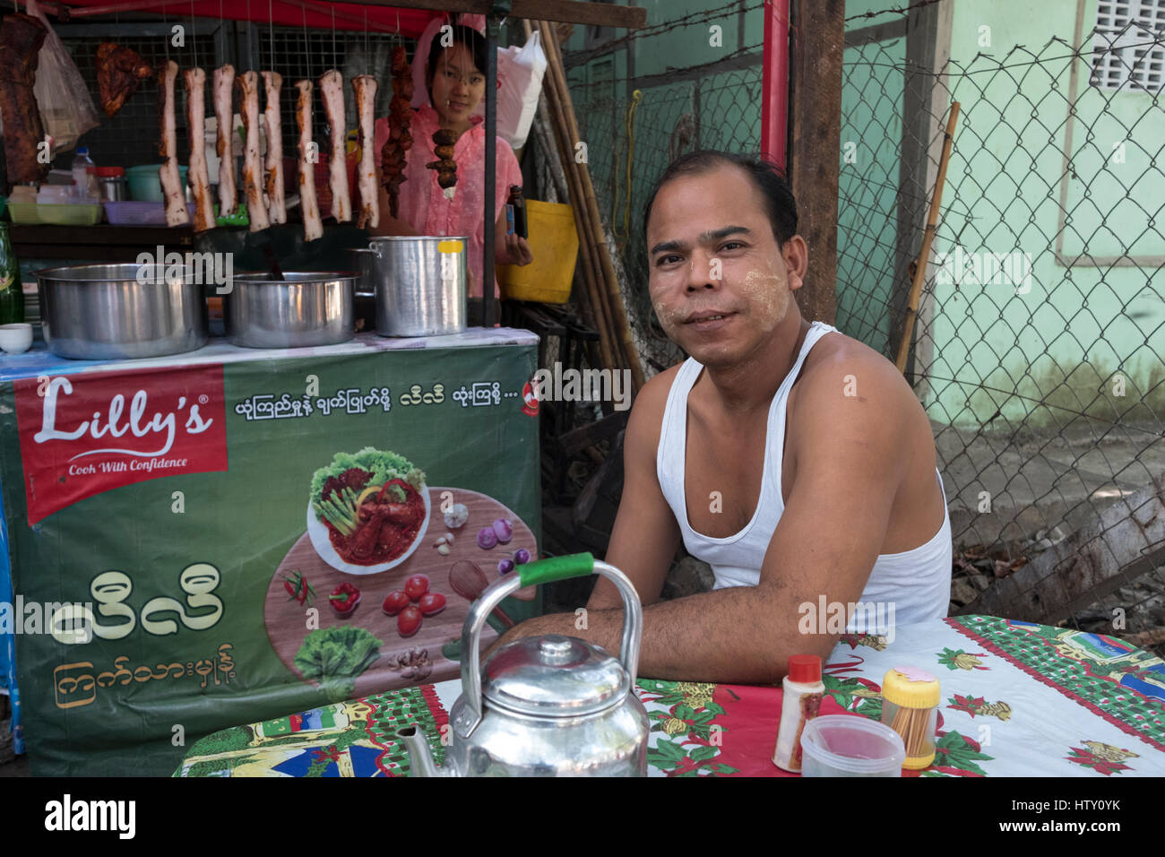 Ein junger Mann entspannt auf einer Pansodan Straße Garküche in Yangon, Region Yangon, Myanmar. Stockfoto