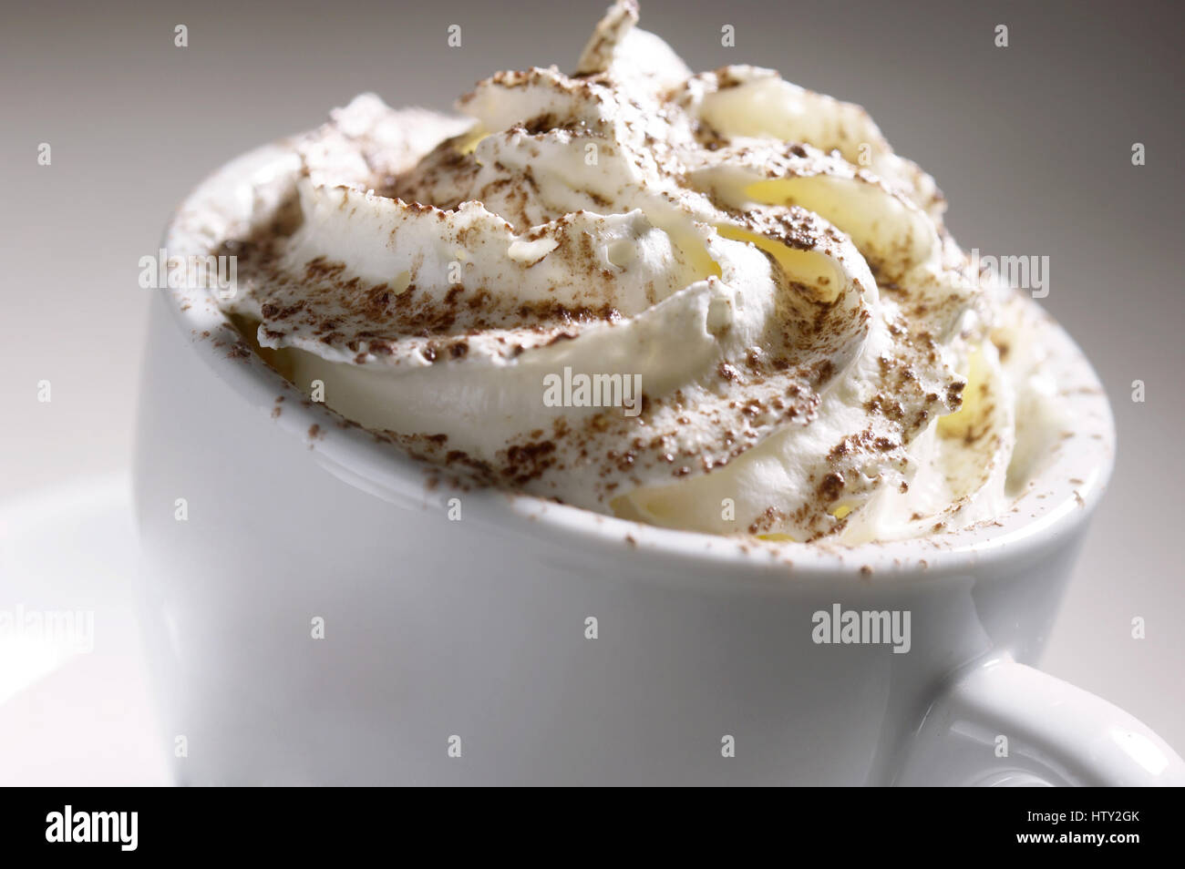 Weiße Tasse Kaffee mit Sahne obenauf Stockfoto