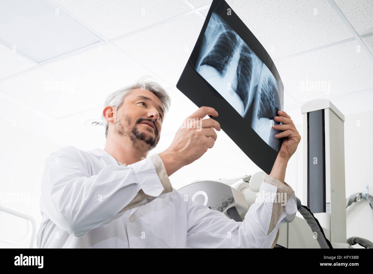 Männliche Radiologe, Röntgen-Thorax im Untersuchungsraum analysieren Stockfoto