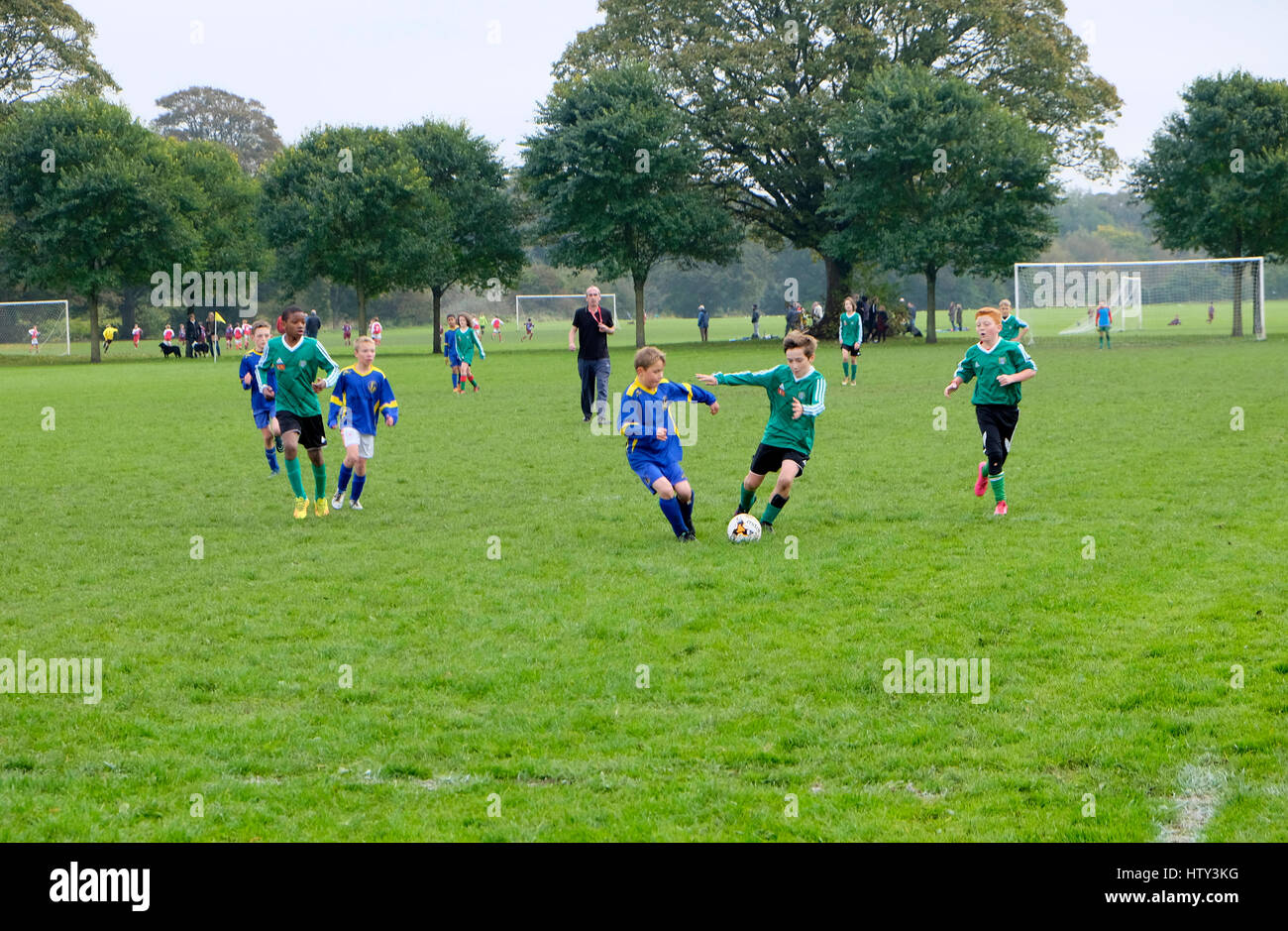 Jungs spielen Fußball in einem Park am Samstagmorgen UK KATHY DEWITT Stockfoto