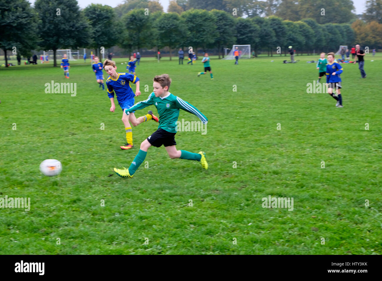 Jungs spielen Fußball (Fußball) in einem Park am Samstag morgen Großbritannien BRITISCHER KATHY DEWITT Stockfoto