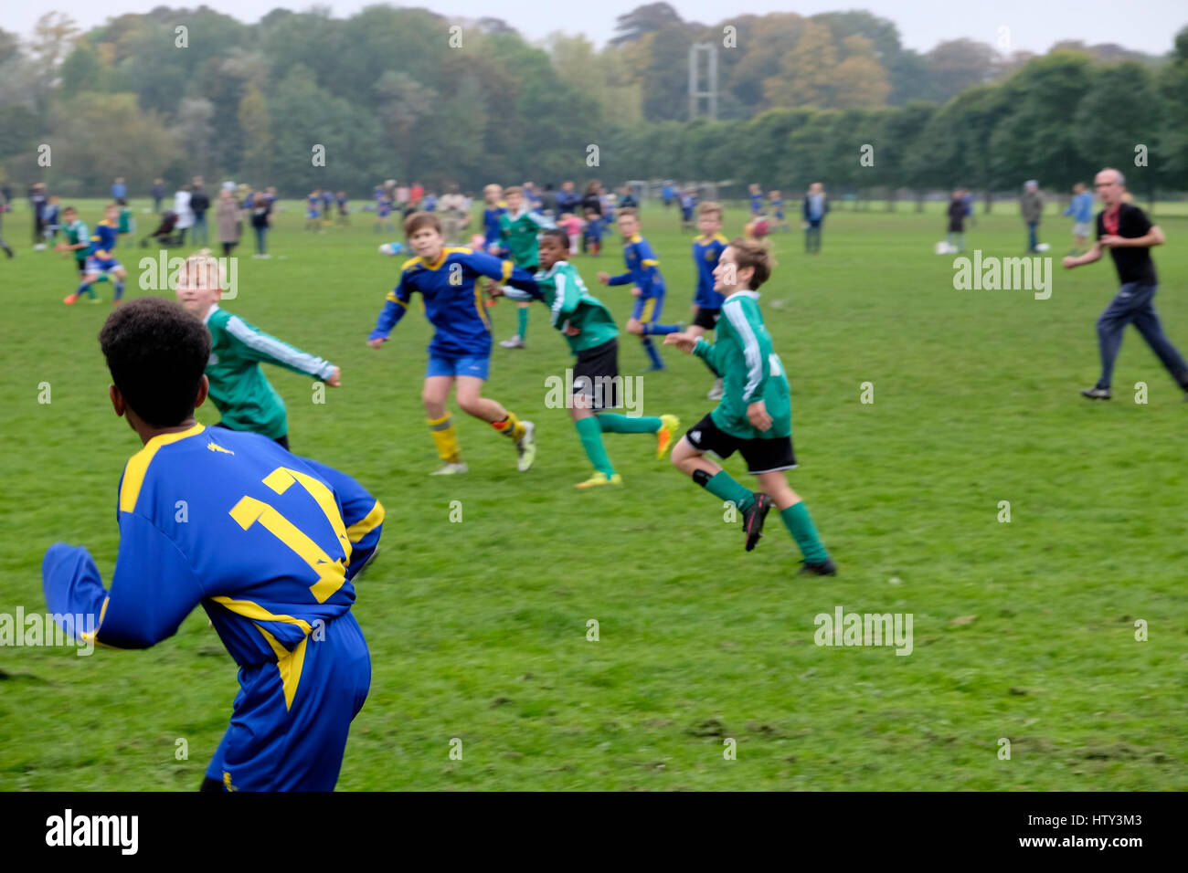 Jungen Kindermannschaften, die an einem Samstagmorgen in Großbritannien, KATHY DEWITT, Teamfußball im Park spielen Stockfoto