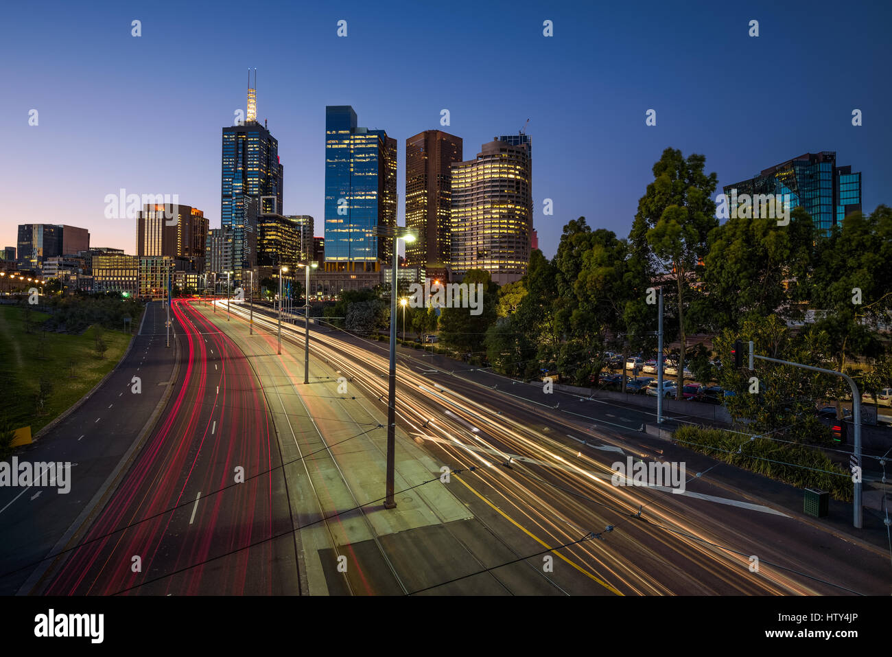Lichtspuren des Verkehrs mit beleuchteten Wolkenkratzern von Melbourne Innenstadt nach Sonnenuntergang in Victoria, Australien Stockfoto