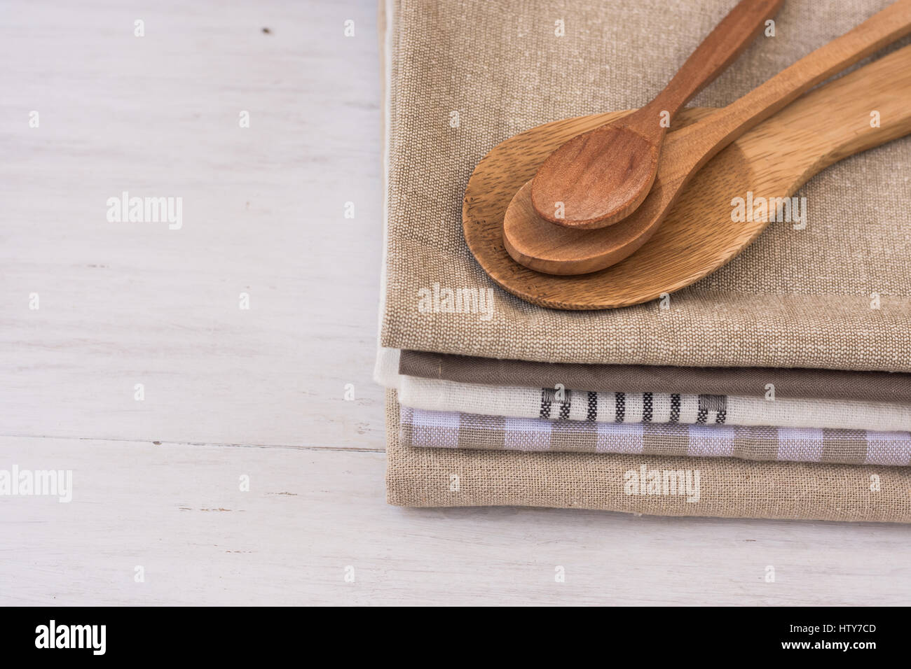 Stapel von Leinen Baumwolle Küchentücher, handgemachte hölzerne Löffel auf weißen Küchentisch, Provence-Stil, Innenarchitektur, coceptual Stockfoto