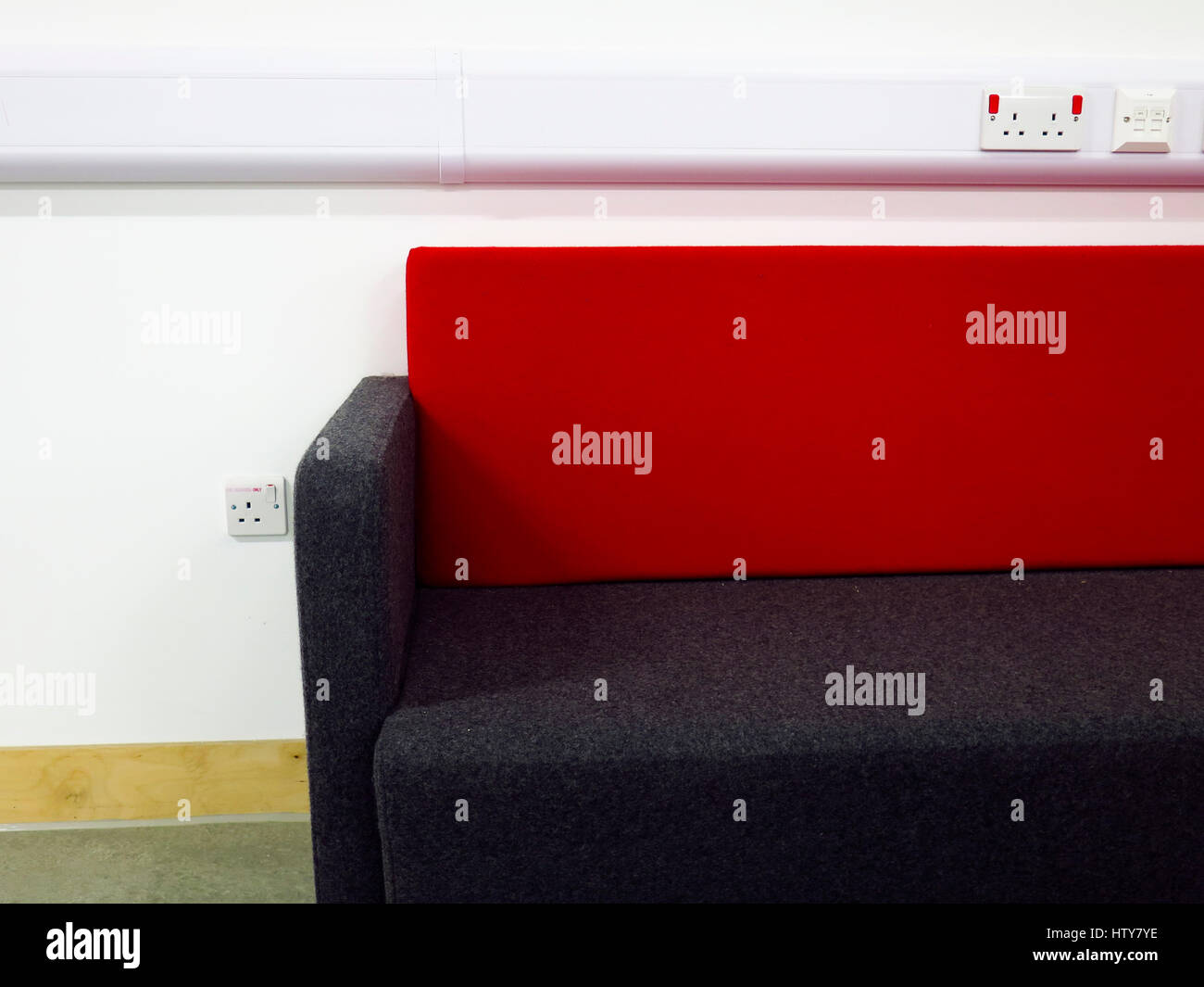Roten und schwarzen Sofa gegen weiße Wand Stockfoto