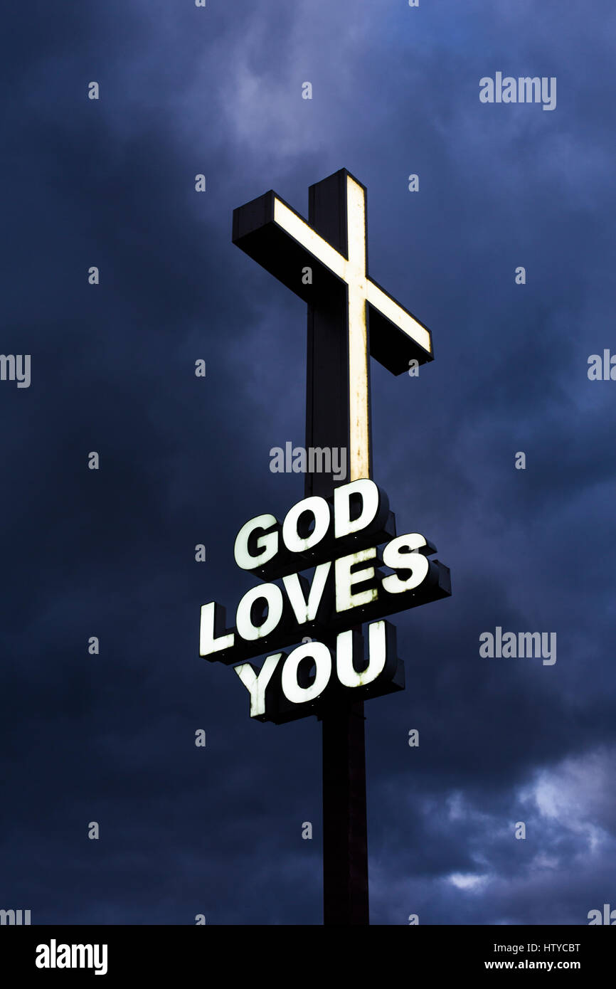 "Gott liebt dich" Neon-Schild gegen eine bedrohliche dunkle Himmel Stockfoto