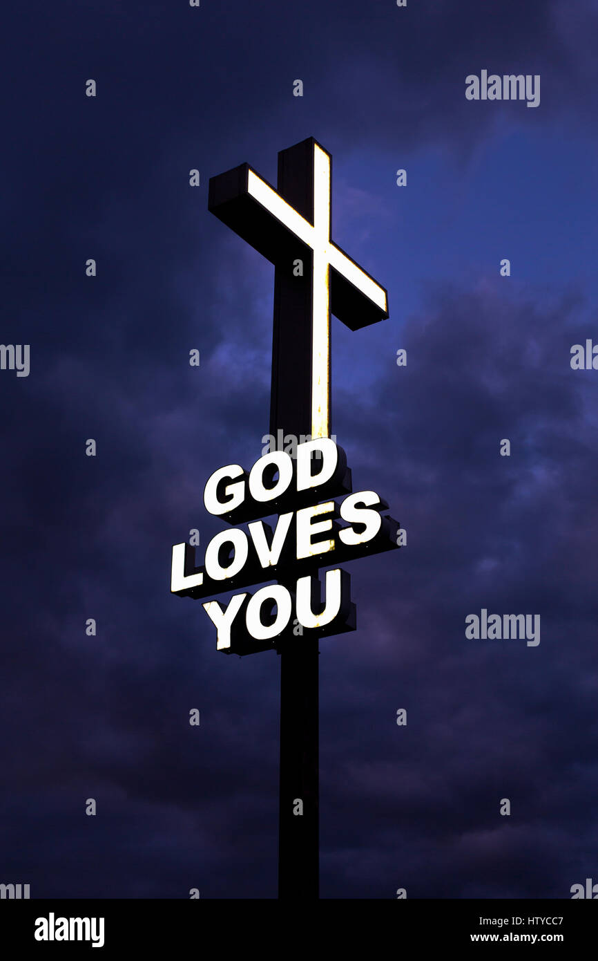 "Gott liebt dich" Neon-Schild gegen eine bedrohliche dunkle Himmel Stockfoto