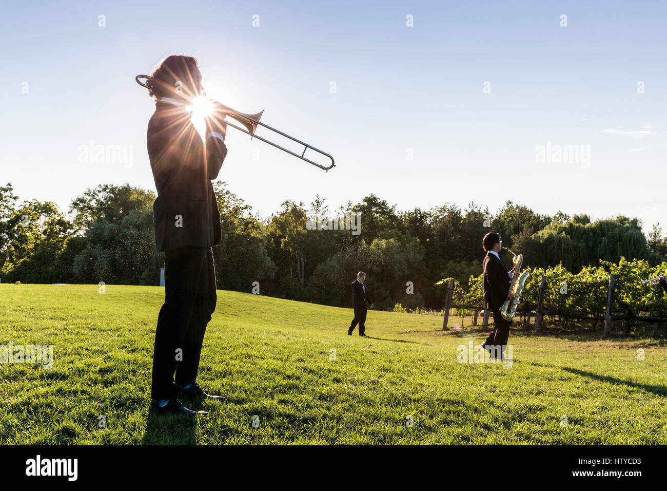 Musiker spielen eine Posaune im freien gegen einen blauen Himmel und Sonne platzen Stockfoto